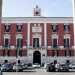 Di fronte al politeama si staglia invece limponente Palazzo della Prefettura, di severo stile neoclassico. Progettato dopo che nel 1806 Bari strapp a Trani il titolo di capoluogo di provincia, si presenta con un prospetto di colore bianco e rosso, scandito da finestre timpanate e coronato da un cornicione al centro del quale si eleva la particolare torretta dellorologio